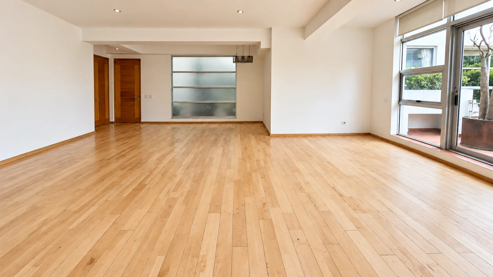 La misma habitación con el piso de fresno uniforme y renovado