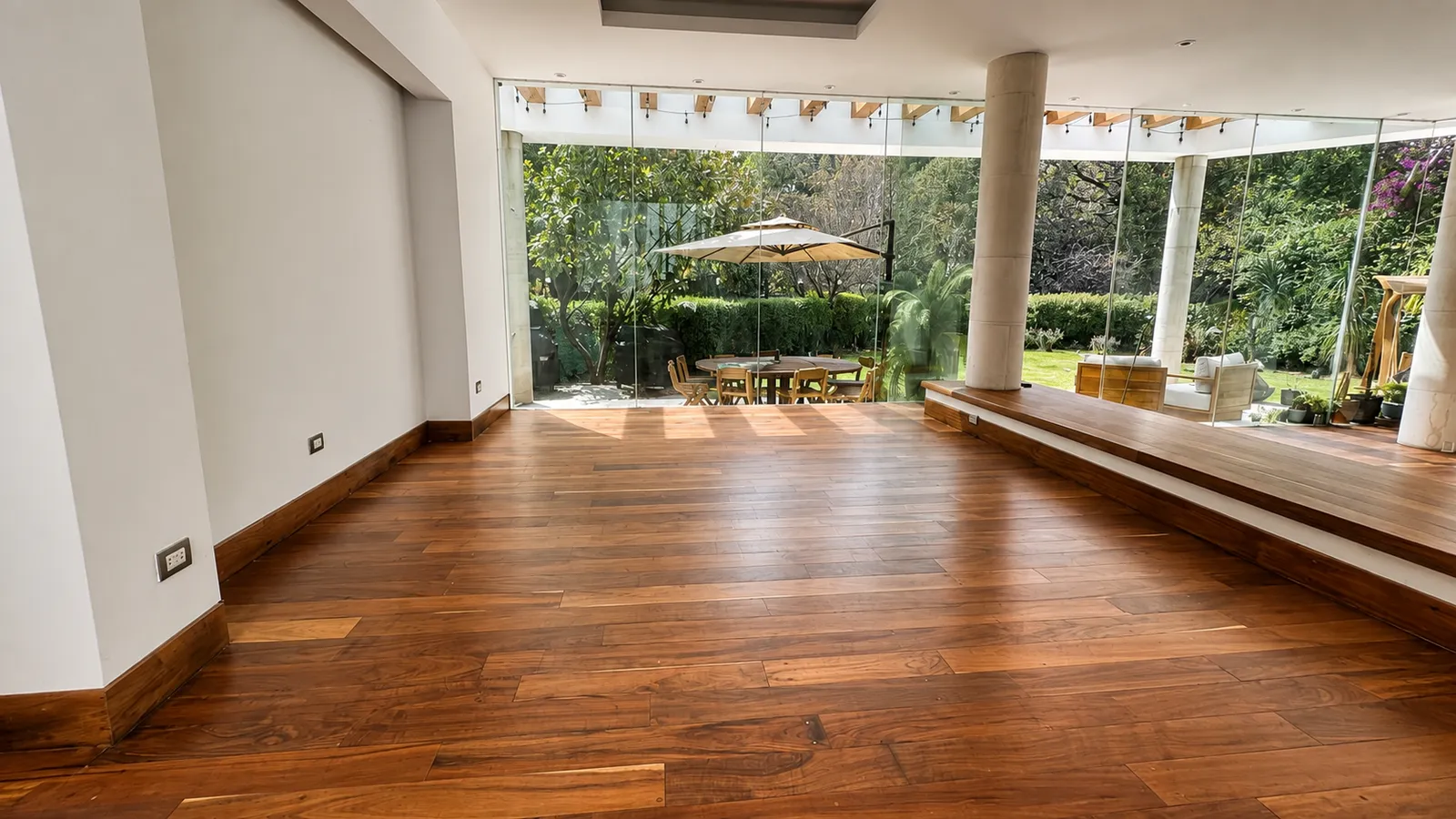 Piso de madera oscura en sala residencial con vista al jardín