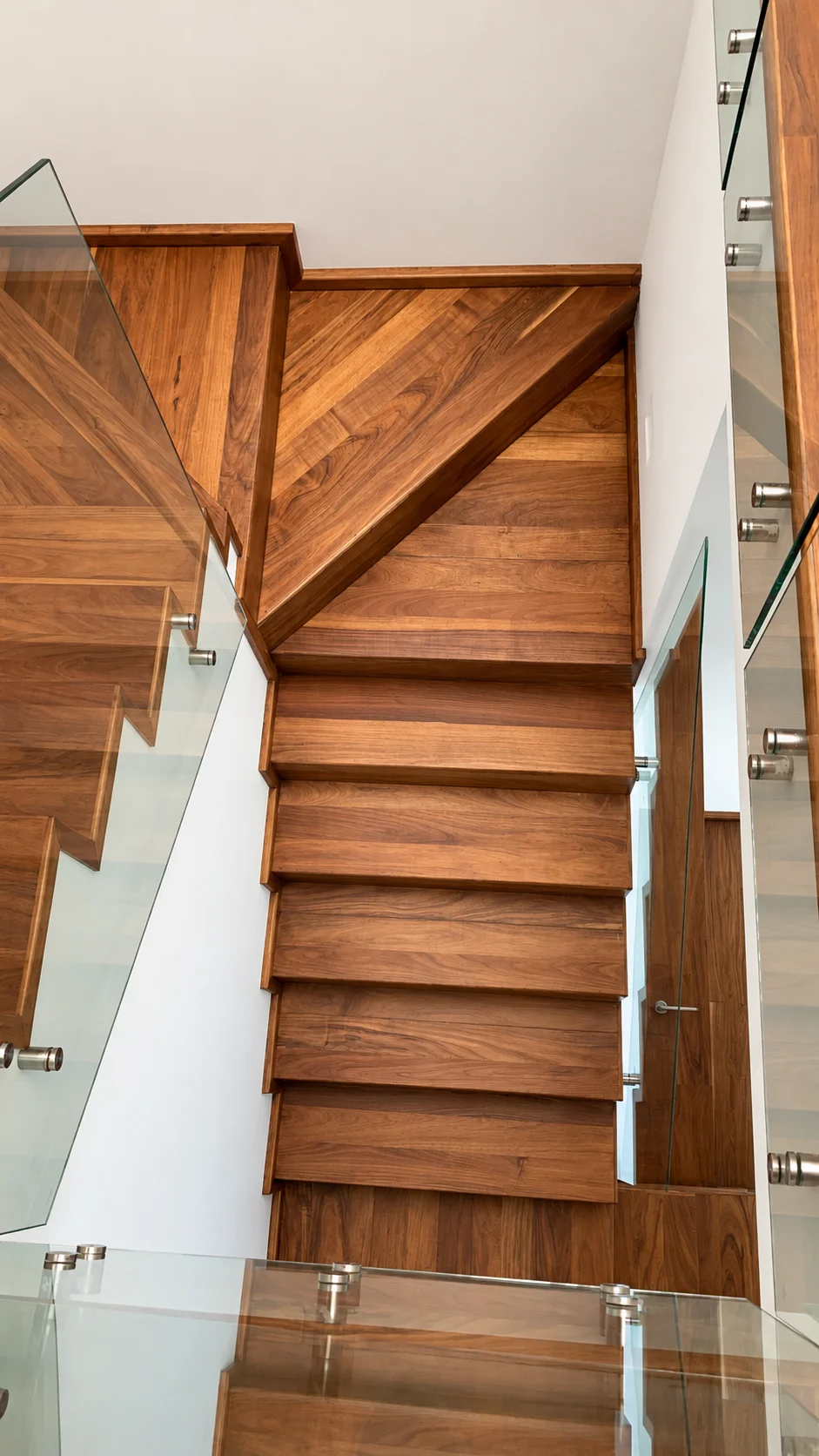 Escalera moderna de madera renovada con barandales de cristal